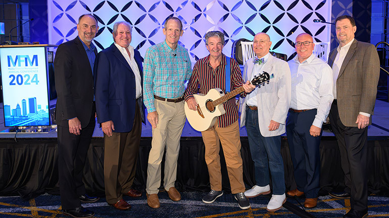 Pictured before Terry Sylvester of the Hollies takes center stage at the Media Financial Management Association Conference in Jacksonville (L to R): Midwest Communications CFO Paul Rahmlow, Szabo Associates President Robin Szabo,  BMI’s Dan Spears, The Hollies’ Terry Sylvester,  Manship Media CFO Ralph Bender, Dotdash Meredith VP Kevin Schmitz, Media Financial Management CEO Joe Annotti.