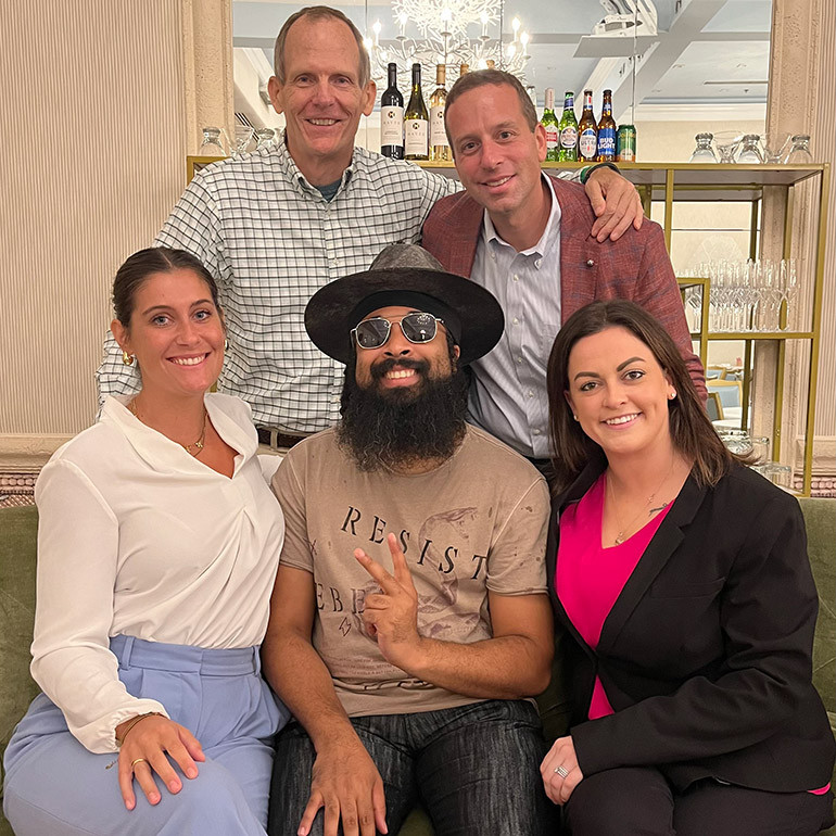 Pictured before BMI songwriter Nelson Cade III hit the stage at the 2024 Seasonal Connect Summit in Palm Beach (L to R): Standing:  BMI’s Dan Spears, Seasonal Connect Founder/CEO Keith Pabian. Sitting:  Seasonal Connect Member Services Manager Colleen Debold, BMI songwriter Nelson Cade III, Seasonal Connect Founder/COO Carly Eglin.